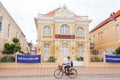 Cambodian man riding bike past old french colonial building of N Royalty Free Stock Photo